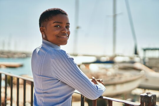 Young african american woman smiling happy standing at the port.