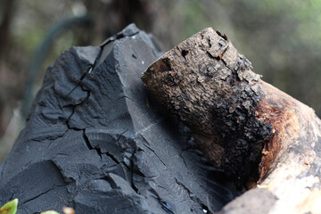 Natural background featuring brown wood material and black coal. Horizontal image