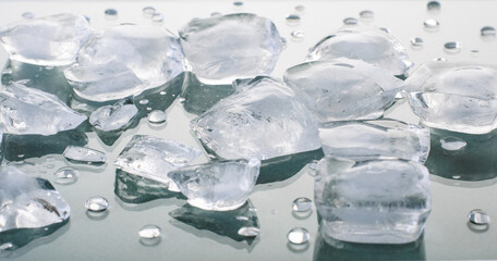 Melting ice cubes on a glossy gray-blue background. ingredient for cold summer drinks