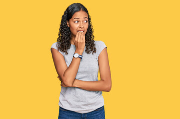 Young african american girl wearing casual clothes looking stressed and nervous with hands on mouth...