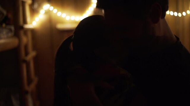 a close up of a couple dancing and kissing in the dark in the candle light 