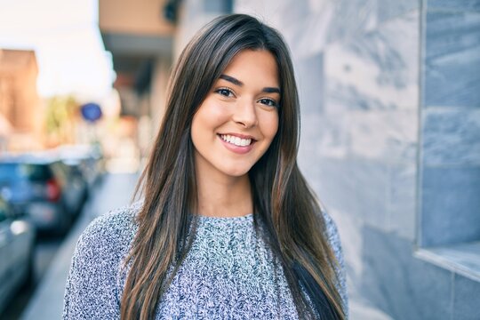 Young beautiful hispanic girl smiling happy walking at the city.
