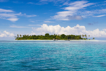 Ideal Untouched tropical paradise island with blue waters, and blue sky in the middle of the photo,...
