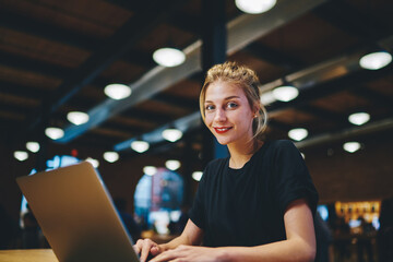 Portrait of happy Caucaisan copywriter smiling at camera while doing distance job in coworking...