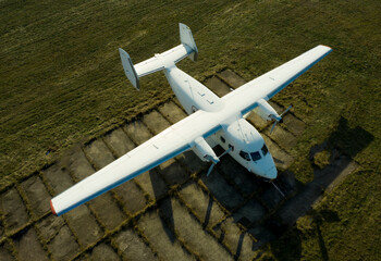 A small plane stands in the parking lot of an old airfield. Wings. Airport. Airfield. Flights by plane.