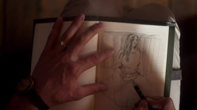 a close up of man hands drawing a portrait of a girl sitting next to him dressed in a maxi dress
