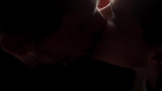 a close up of a couple kissing in the light
