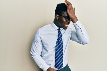 Handsome black man wearing glasses business shirt and tie surprised with hand on head for mistake, remember error. forgot, bad memory concept.