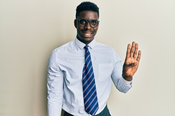 Handsome black man wearing glasses business shirt and tie showing and pointing up with fingers number four while smiling confident and happy.