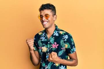 Young handsome african american man wearing summer style celebrating surprised and amazed for success with arms raised and eyes closed