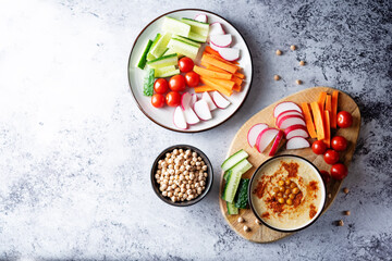 Hummus appetizer with carrot, radish, tomato and cucumber