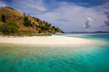 Obraz premium The island with the hill and its white sandy beach going down right into turquoise waters of the clean ocean around, Nusa Tenggara, Indonesia