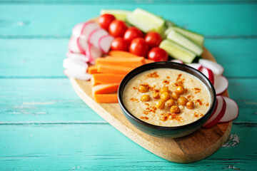 Hummus appetizer with carrot, radish, tomato and cucumber