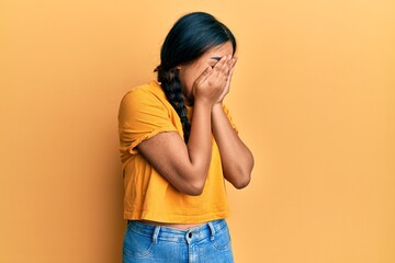 Young latin woman wearing casual clothes with sad expression covering face with hands while crying....