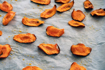 Selective focus. Carrot chips on a baking sheet. Fresh baked ,vivid colors. Homemade carrot chips.