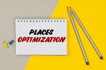 On a yellow-gray background are pencils, buttons and a notebook in which it is written - PLACES OPTIMIZATION