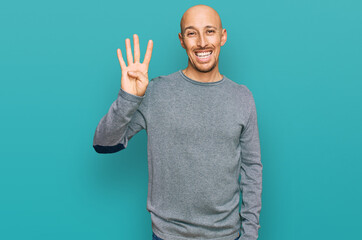 Bald man with beard wearing casual clothes showing and pointing up with fingers number four while smiling confident and happy.