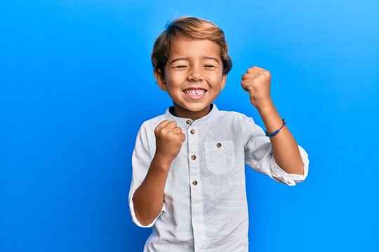 Naklejki Adorable latin kid wearing casual clothes celebrating surprised and amazed for success with arms raised and eyes closed