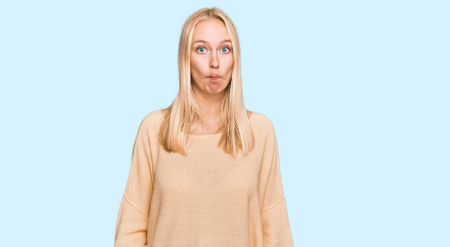 Young blonde girl wearing casual clothes making fish face with lips, crazy and comical gesture. funny expression.