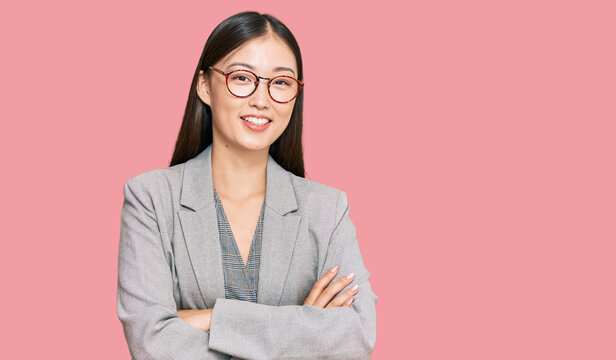 Young chinese woman wearing business clothes happy face smiling with crossed arms looking at the camera. positive person.