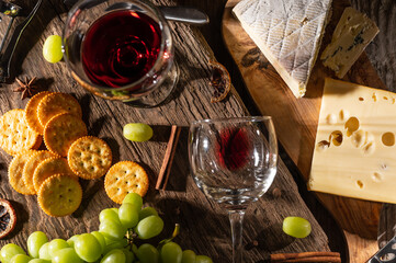 Different sorts of cheese and wine for tasting. Top view on wooden background