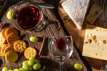 Different sorts of cheese and wine for tasting. Top view on wooden background