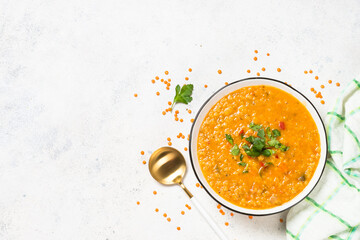 Lentil soup with vegetables at white stone table.