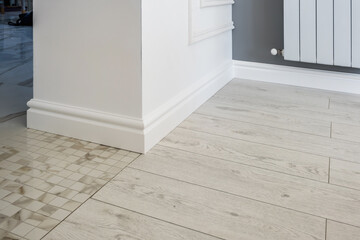 Detail of corner flooring with intricate crown molding and plinth.