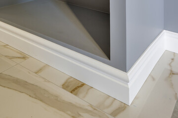 Detail of corner flooring with intricate crown molding and plinth.