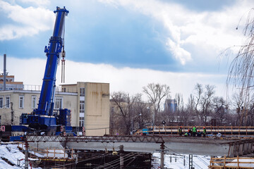 Obraz premium Workers in protective helmets are repairing bridge in Voronezh