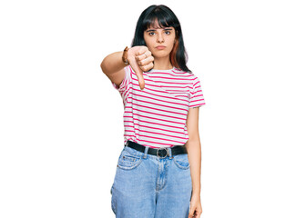 Young hispanic girl wearing casual clothes looking unhappy and angry showing rejection and negative with thumbs down gesture. bad expression.
