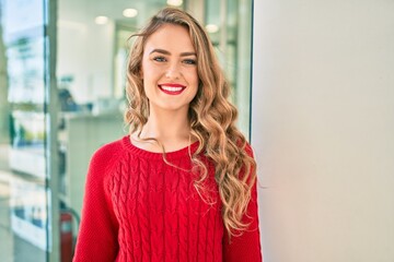 Young blonde girl smiling happy walking at the city.