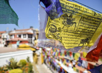 Close-up of colorful prayer flags hanging on Boudhanath stupa. Shallow depth of field. Kathmandu, Nepal.