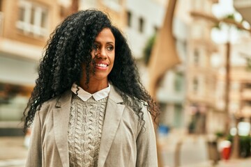 Middle age african american businesswoman smiling happy standing at the city.