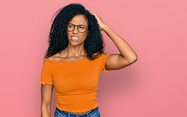 Middle age african american woman wearing casual clothes and glasses confuse and wonder about question. uncertain with doubt, thinking with hand on head. pensive concept.