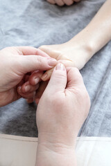 Adult woman massage therapist. is massaging woman's fingers to make them relaxed after spa sessions.
