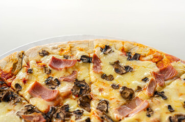 Freshly baked large pizza with ham, mushrooms and mozzarella on a traditional dough