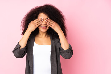 Young african american woman over isolated background covering eyes by hands and smiling