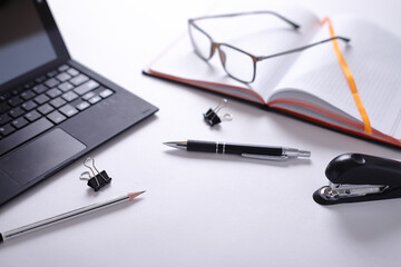 computer glasses notebook pen pencil and stapler on white background - obrazy, fototapety, plakaty