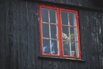 red wooden window at a dark house