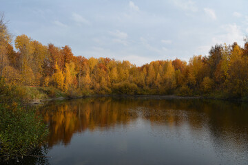 Beautiful autumn landscape with lake and colorful trees on its bank.