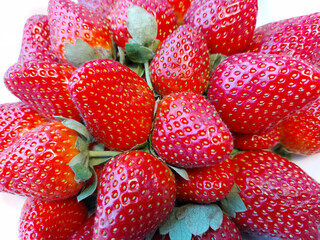 Ripe red large strawberries on a white background