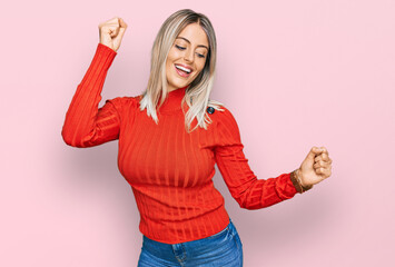 Beautiful blonde woman wearing casual clothes dancing happy and cheerful, smiling moving casual and confident listening to music