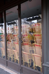 A restaurant closed in Paris during the coronavirus pandemic the 26th march 2021. A view of some chairs stacked in the showcase at a closed parisian restaurant.