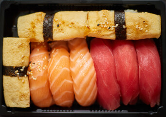 Nigiri sushi set in plastic container ready for takeout delivery. Closeup of take away lunch box