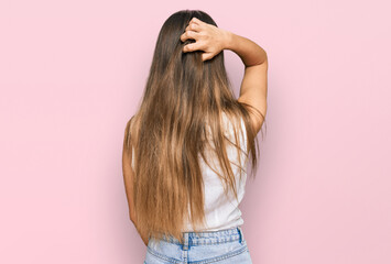 Young hispanic woman wearing casual clothes backwards thinking about doubt with hand on head