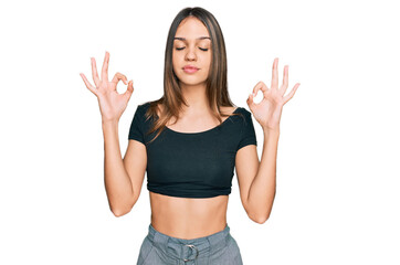 Fototapeta na wymiar Young brunette woman wearing casual clothes relax and smiling with eyes closed doing meditation gesture with fingers. yoga concept.