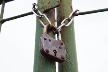 A gate closed with a padlock - focus on the padlock	

