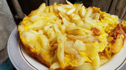 Potato gratin casserole in white baking dish with eggs and golden crust. Rustic authentic recipe of homemade cuisine. Potatoes sliced like French fries and roasted in oven with egg liaison
