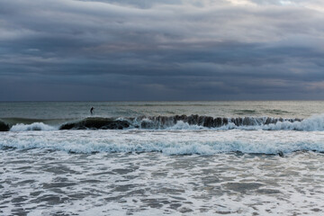 Naklejka na ściany i meble Seascape of the Mediterranean sea after a storm, surfers practicing bodyboar on the waves